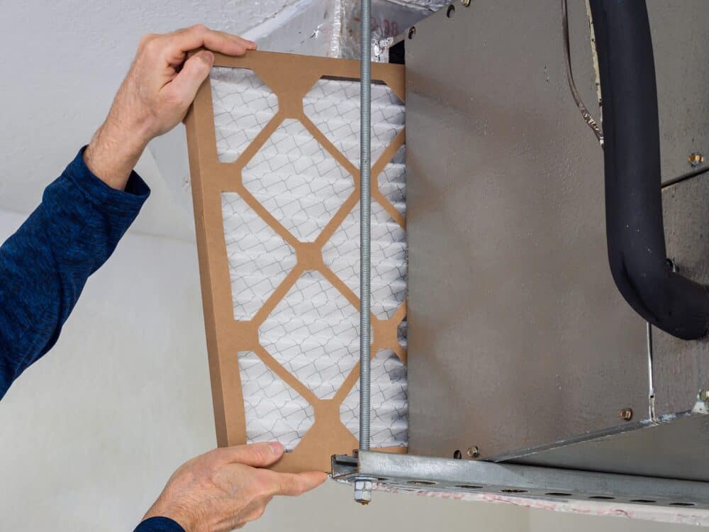 HVAC technician replacing a furnace filter in New Jersey furnace
